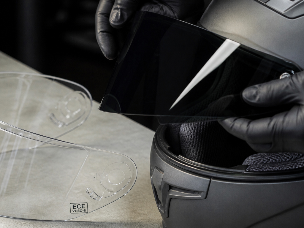 Comparison of a tinted motorcycle helmet visor and a certified clear visor.