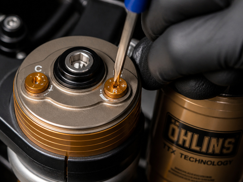 Close-up of adjusting compression and rebound damping clickers on a motorcycle fork.